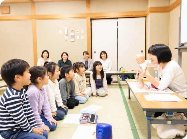 いのちの授業で、赤ちゃんの人形を使いながら子どもたちに語りかける講師の様子